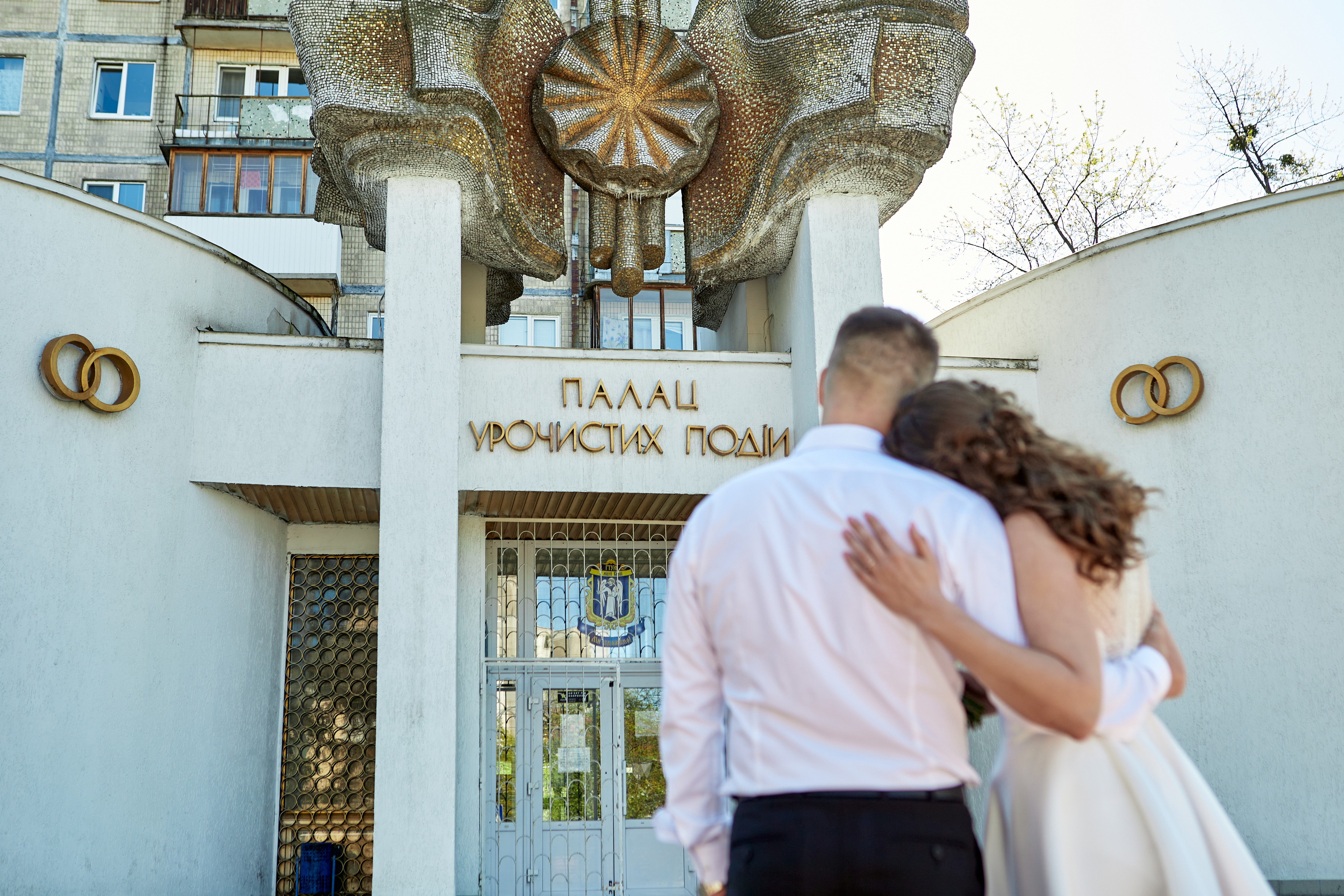 Фотографія молодят на фоні будівлі для урочистої церемонії Дніпровського РАЦС (ЗАГС) Київ